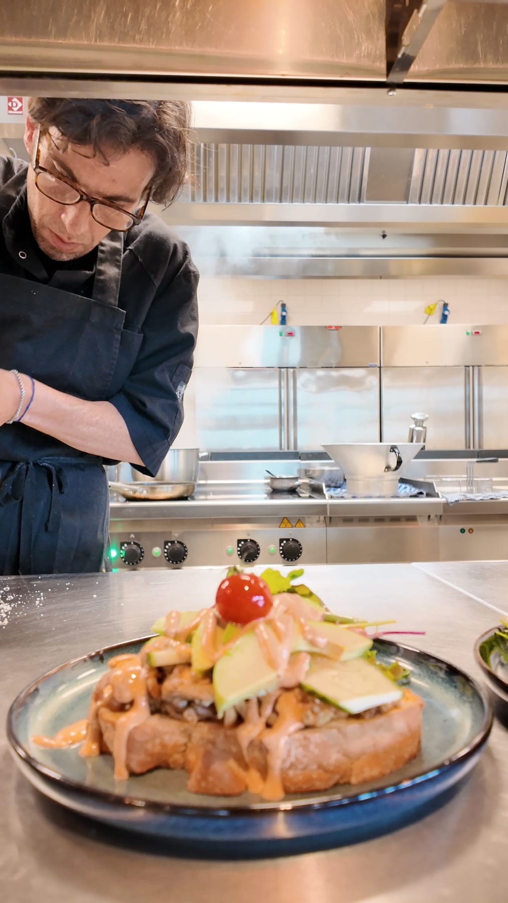Chef Sergio aan de pass in de keuken, met een afgewerkt bord op de voorgrond