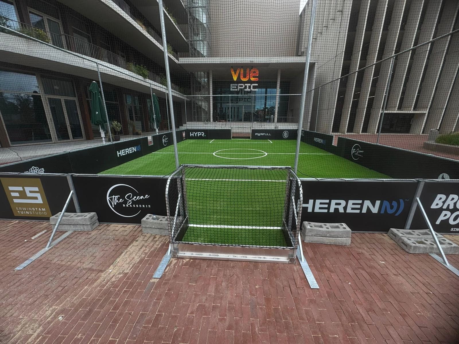 De grasmat van dichtbij met de boardings op de achtergrond